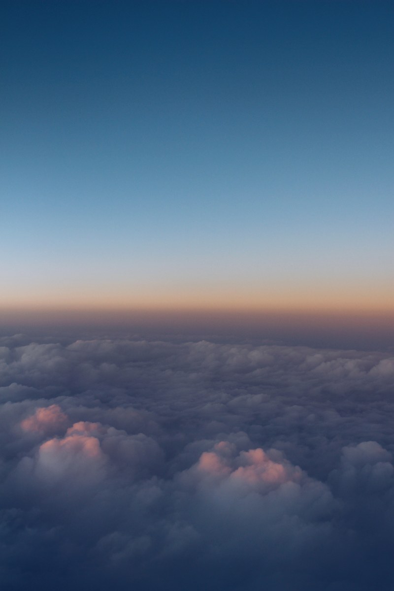 a sea of clouds seen from above during sunset, up in the clouds 4k