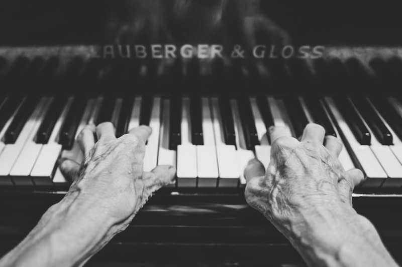 a black and white shot of an elderly persons hands playing a lauberger amp gloss piano, lauberger amp gloss keyboard in black and white 4k