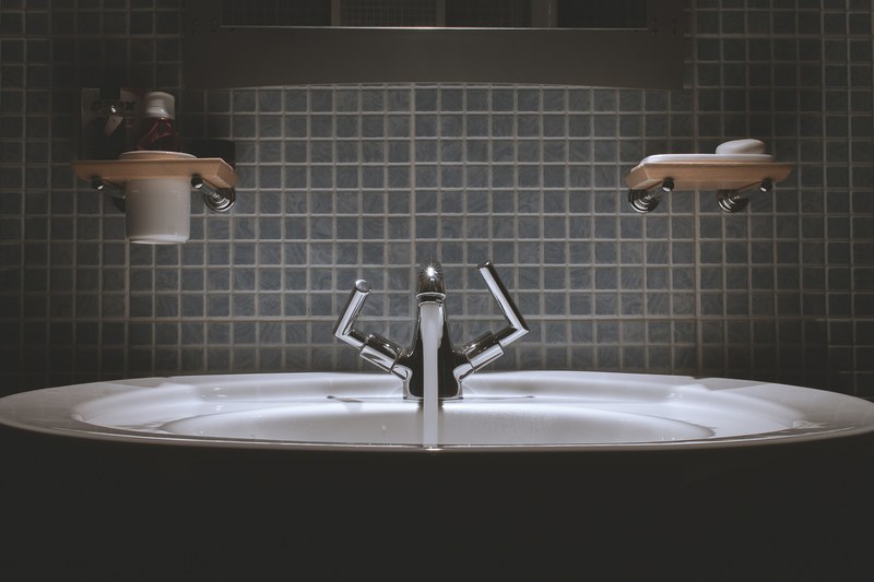 a silver sink faucet in a bathroom with a blue tile backsplash, bathroom sink 4k