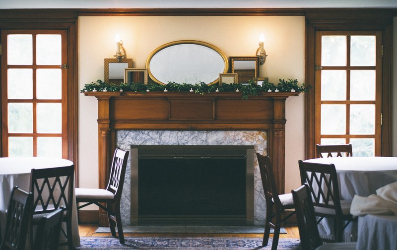 interior of a dining hall with a large fireplace in the center, _dining hall 4k