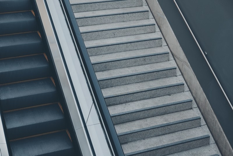 an escalator next to concrete stairs, empty stairs 4k