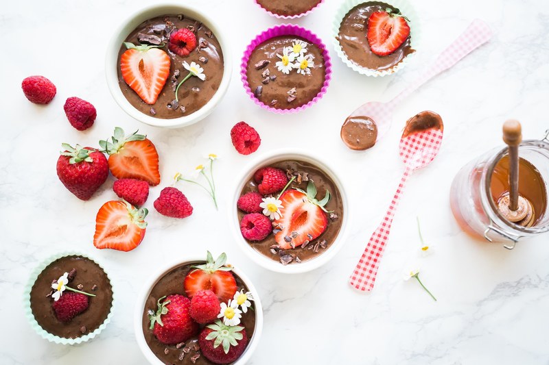 cupcake filters and bowls filled with chocolate mixture chocolate pieces strawberries raspberries and daisies beside half dipped plastic spoons and a honey jar, cravings 4k