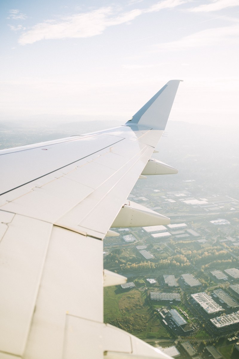 a view from an airplane window on its wing and a town underneath, pdx gt lax 4k
