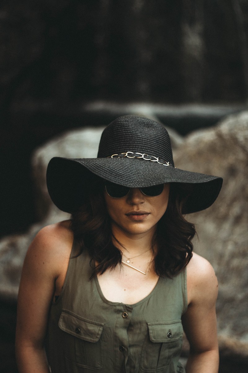 woman in a floppy hat poses confidently, summer fashion 4k