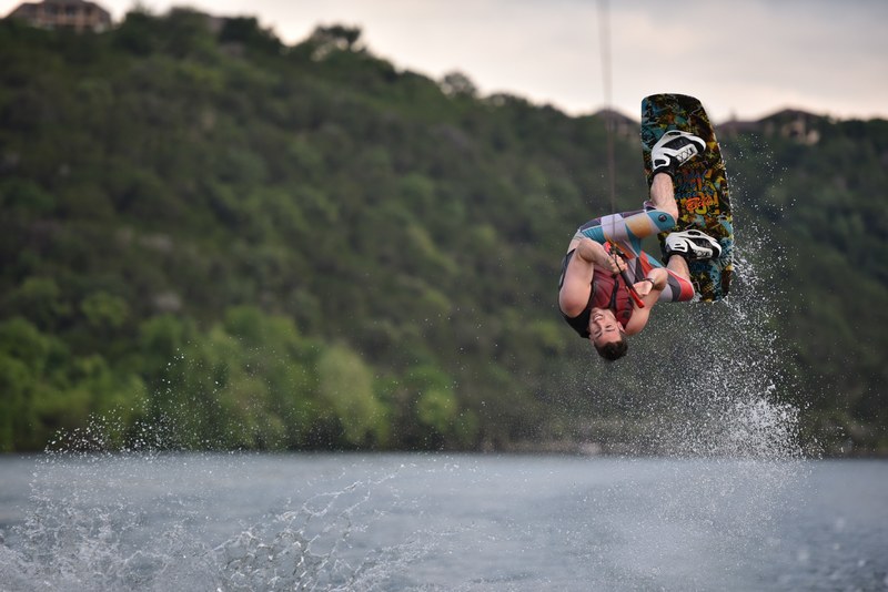 wakeboarding athlete flipping up to the sky in lake austin, male wakeboarder lake austin 4k