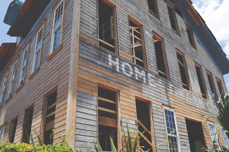 an old wooden building with a fading painted sign on it is being restored, fix er upper 4k