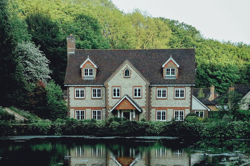 elegant house in london next to a pond and in front of a forested hill, elegant brick house in london 4k