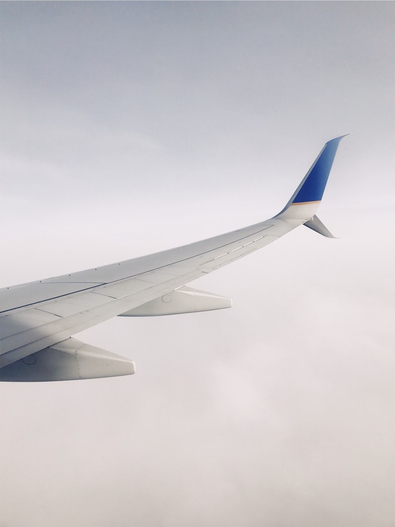 a view from an airplane window on the planes wing and thick clouds below, view on the planes wing 4k