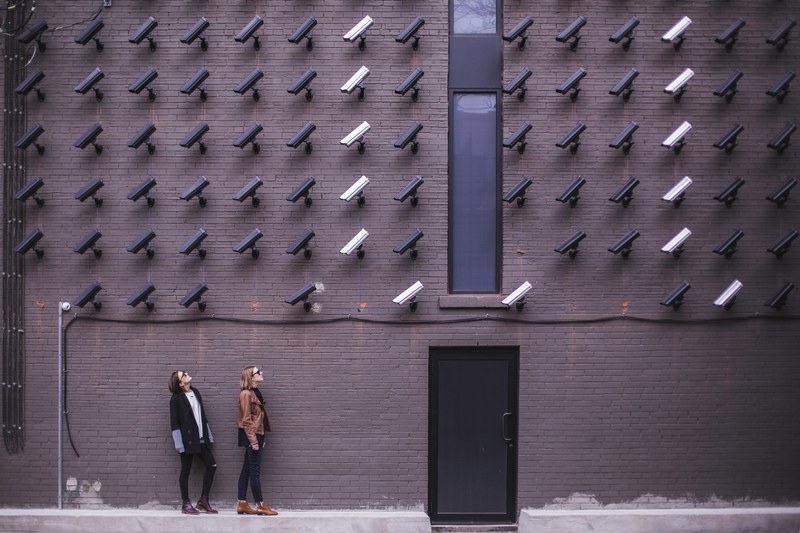 women viewing modern art with black and white surveillance cameras on wall in toronto, women look at security cameras 4k