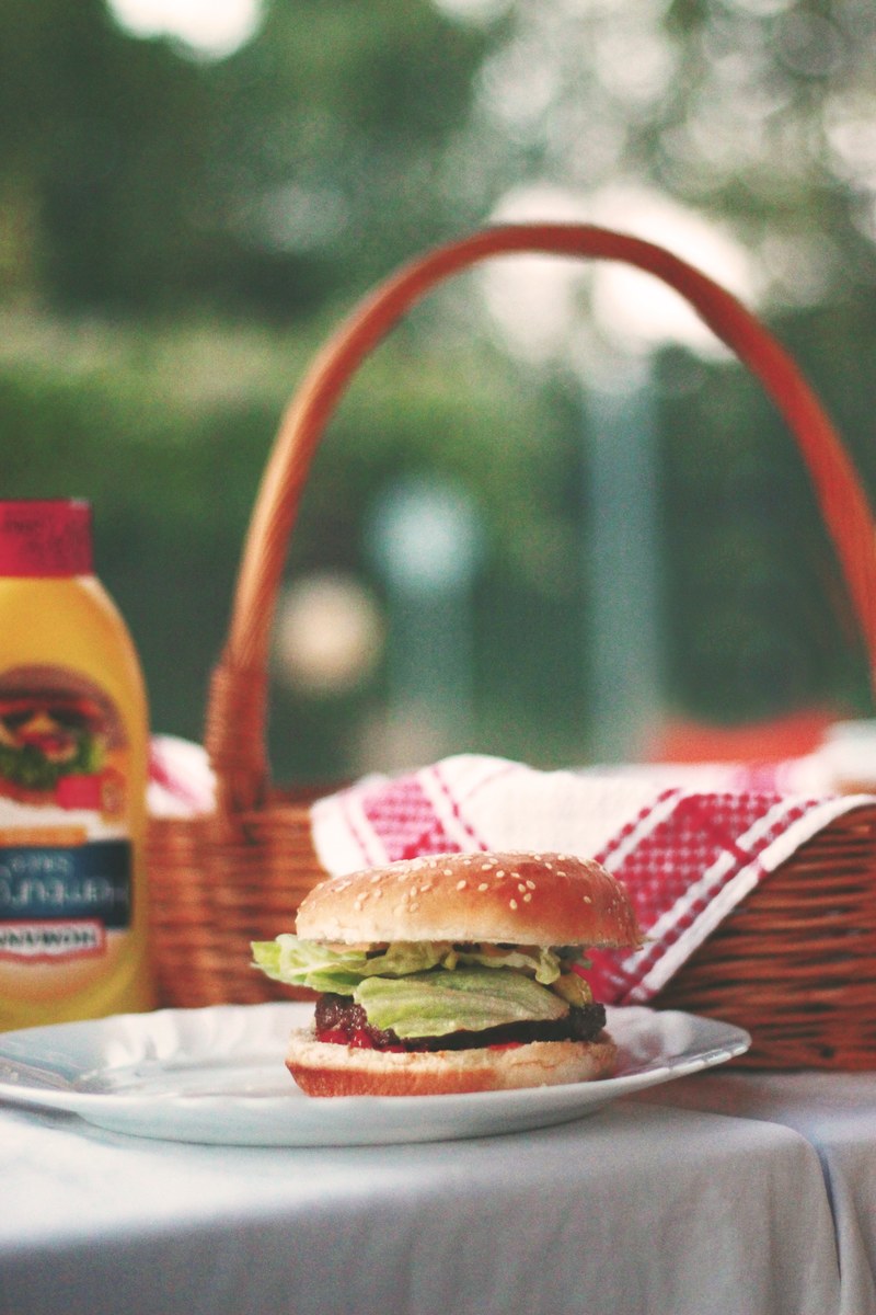 american hamburger on a picnic table by a basket, holiday cook out 4k