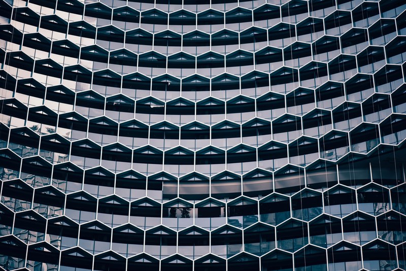 a honeycomb pattern in the facade of a modern office building, honeycomb facade 4k