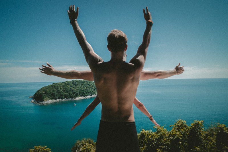 a man standing on a cliff with his arms up with two other people in front of him, _family bonding 4k
