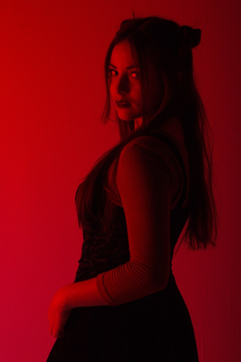 a long haired model cast in red light looks over her shoulder at the camera, more red_ 4k