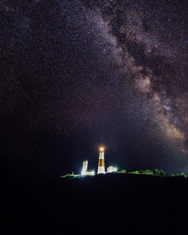 the milky way rises above the montauk point lighthouse during a star studded night, _under the stars 4k