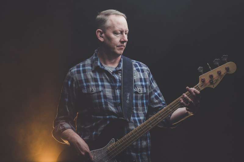a male musician in a checkered shirt playing a fender electric guitar, guitarist with a fender guitar 4k