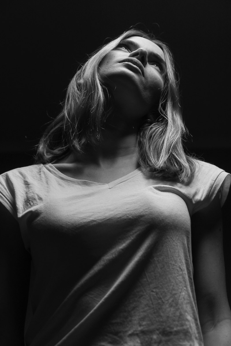 black and white shot of blonde haired young woman with t shirt looking up jerusalem, b_zeltser 4k