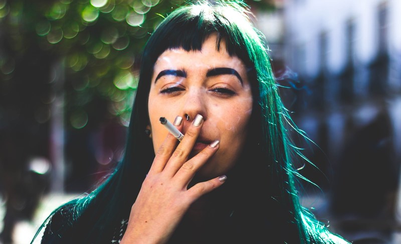 woman with edgy green hair smoking a cigarette outside, urban portrait 4k