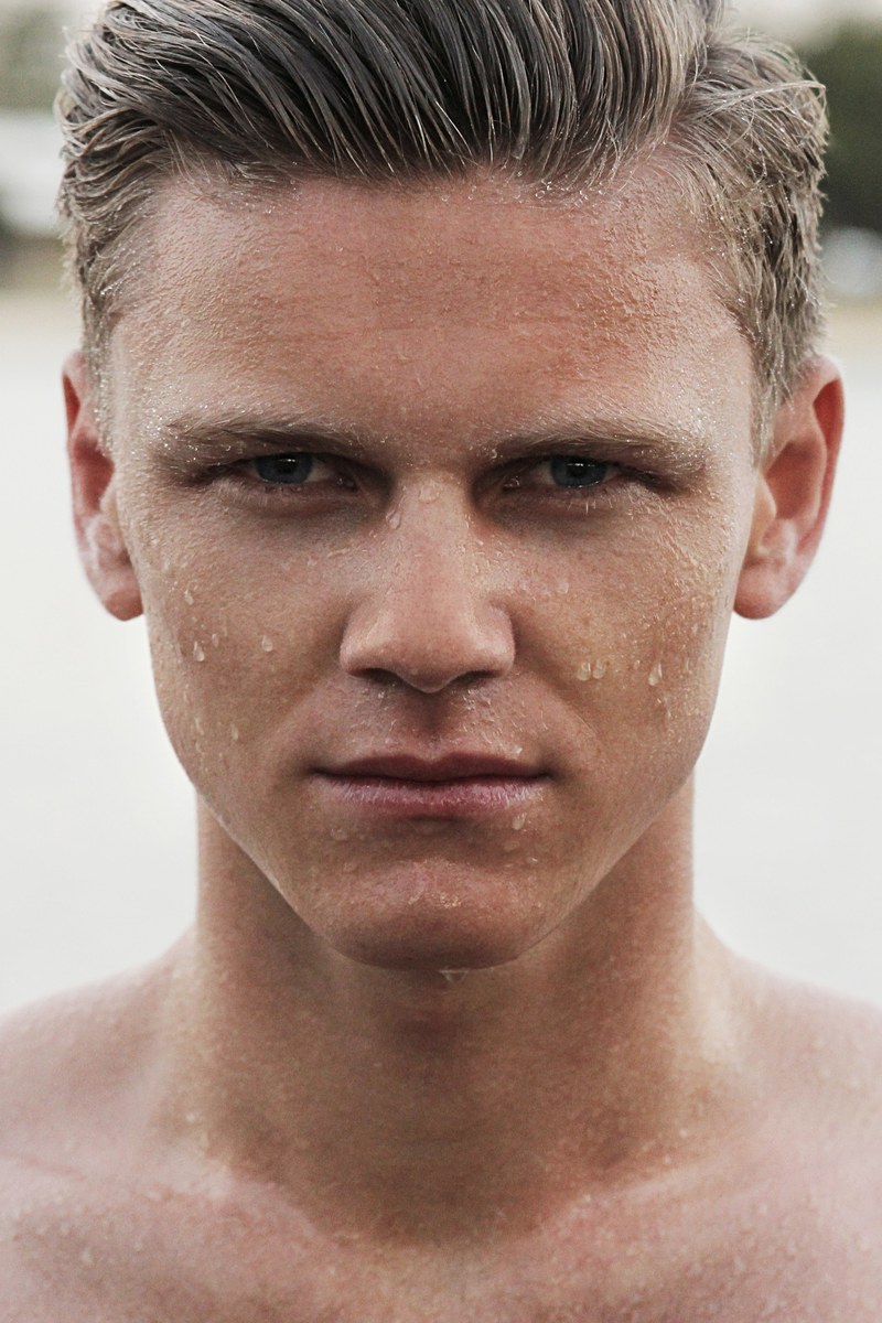 man with water on his face and wet hair staring seriously, staring down the competition 4k