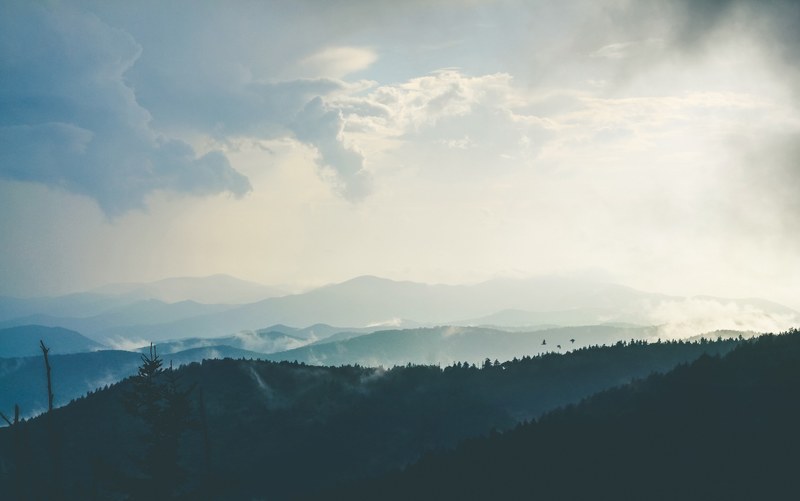 a high view of wooded hills under a cloudy sky, forested hills 4k