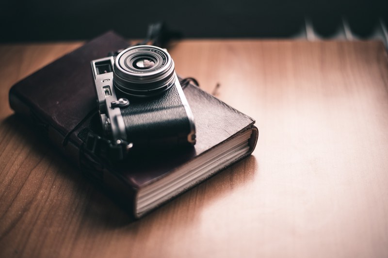 vintage camera on a leather planner on the desk, traveljournal 4k