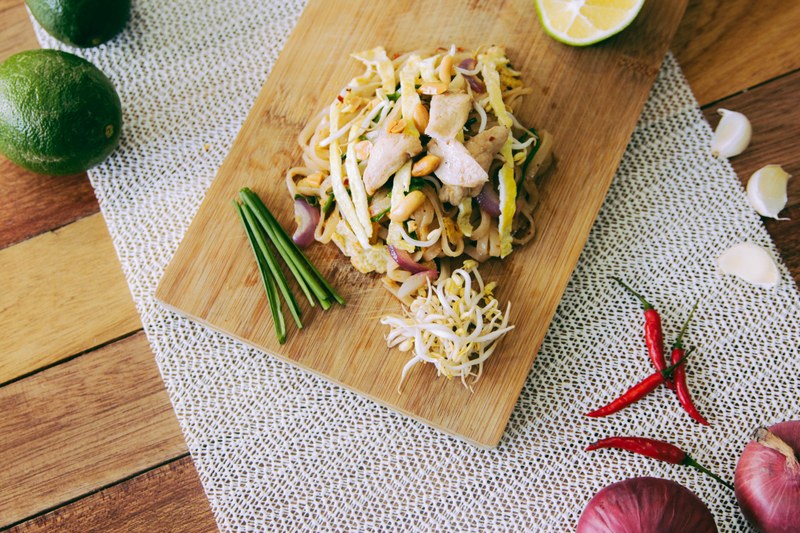 filipino noodle dish with bean sprouts and vegetables on a cutting board, noodle dish 4k