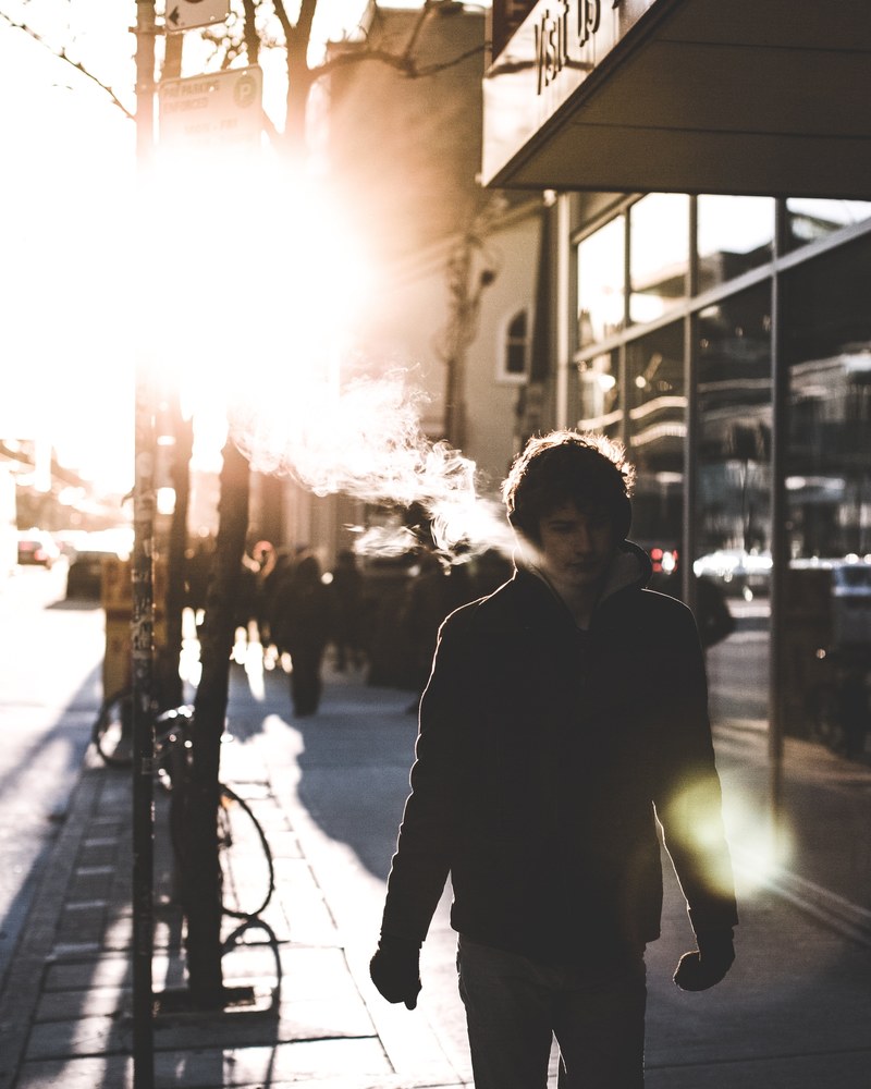 the silhouette of a man walking down the sidewalk with the sun behind him, _sunny breath 4k