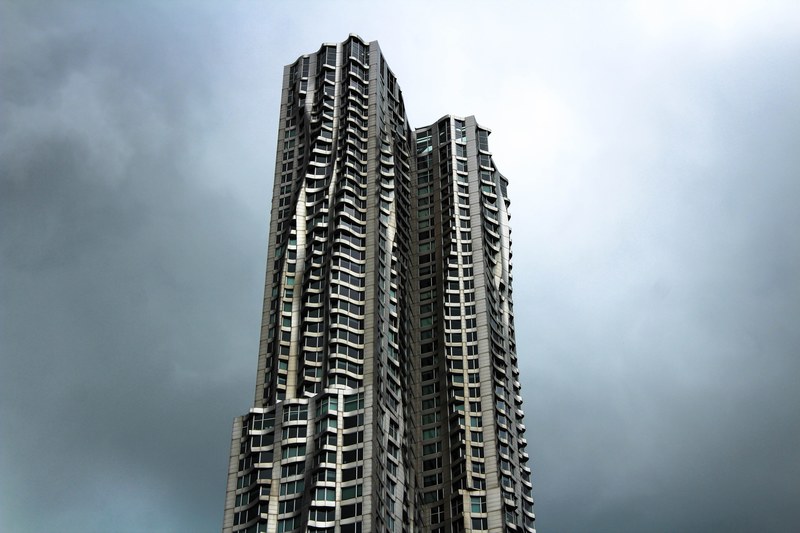 twin skyscrapers with undulating curved facade rise against the gray sky, _twin skyscrapers 4k