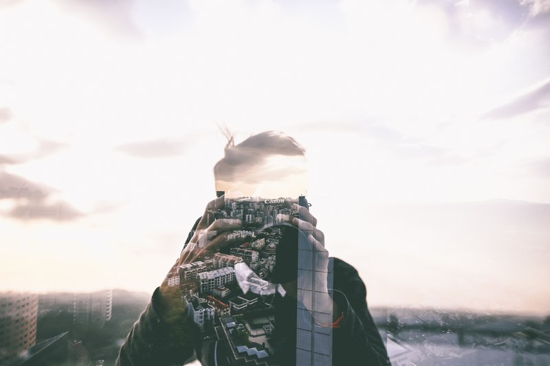 the reflection of the city in a window obscuring the reflection of a photographer with a canon camera, city reflection 4k
