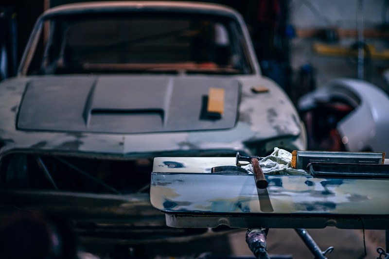 the front view of an old ford mustang being fixed up with mechanics tools on the foreground, _car shop 4k