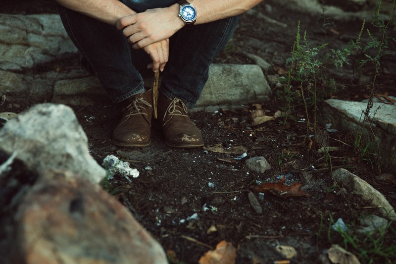 a low shot of a male hiker taking a rest on a rock in a forest in chilhowee, rest during a hike 4k