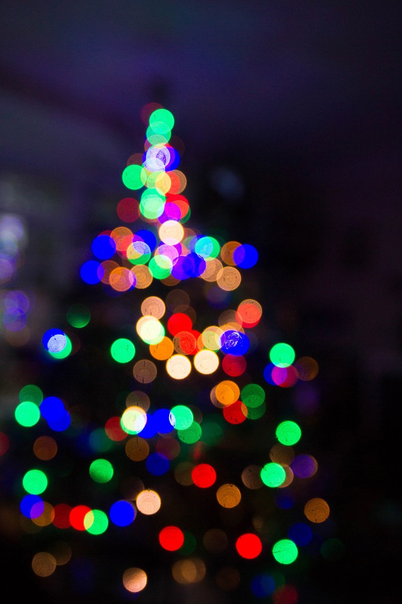 the out of focus festive lights on a christmas tree create a visual blur of dark and light, festive christmas lights create bokeh 4k