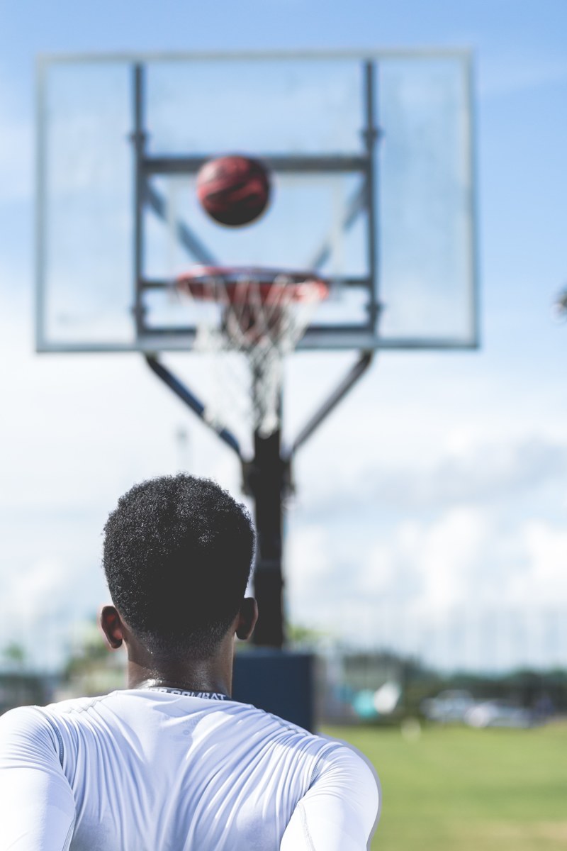 an african american man shooting a basketball into an outdoor net, nothing but net 4k