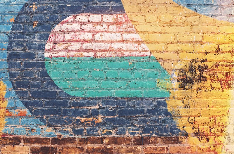 a brick wall in london that is covered with yellow blue green and pink paint, london brick wall 4k