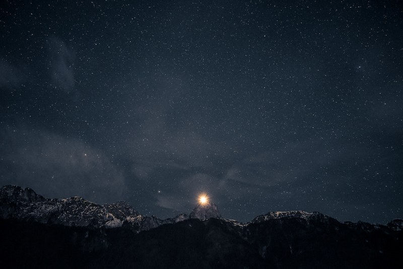 a bright star sits just above the top of a mountain during a starry night, bright star over mountain 4k