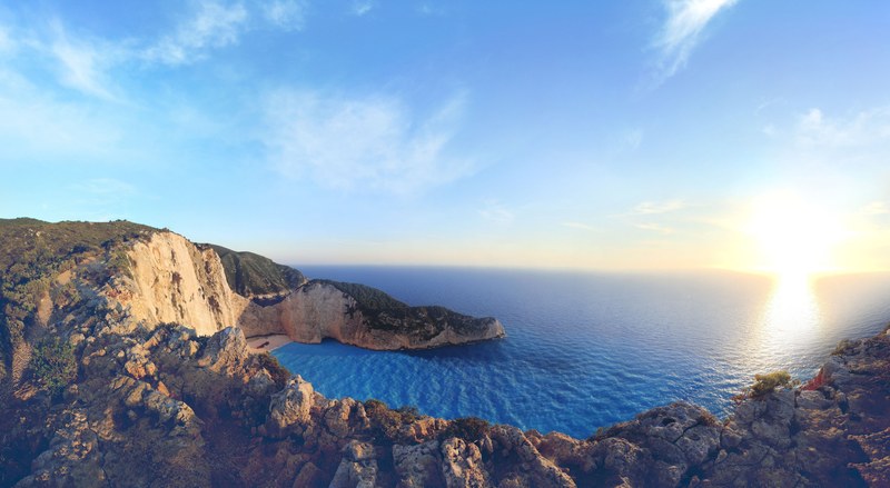 view of the sunrise in the coastal skyline from above the rocky cliffs of navagio greece, coastal sunrise at navagio 4k