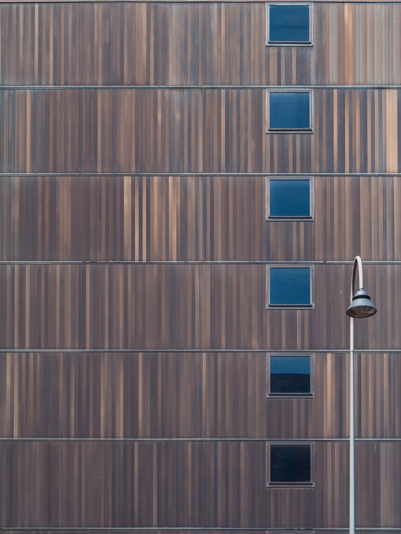 a brown building facade with square windows and a lamppost next to it, brown building facade 4k