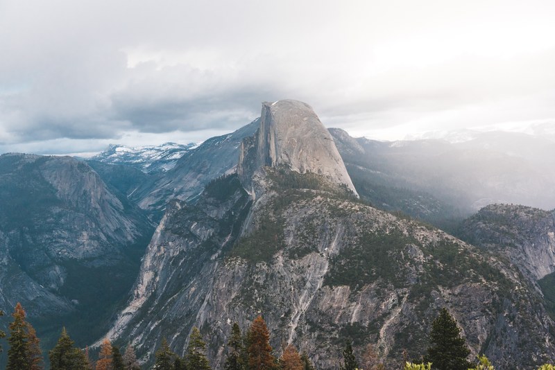 aerial drone shot of snowy mountains in glacier point on a misty day, glacier point through the fog 4k