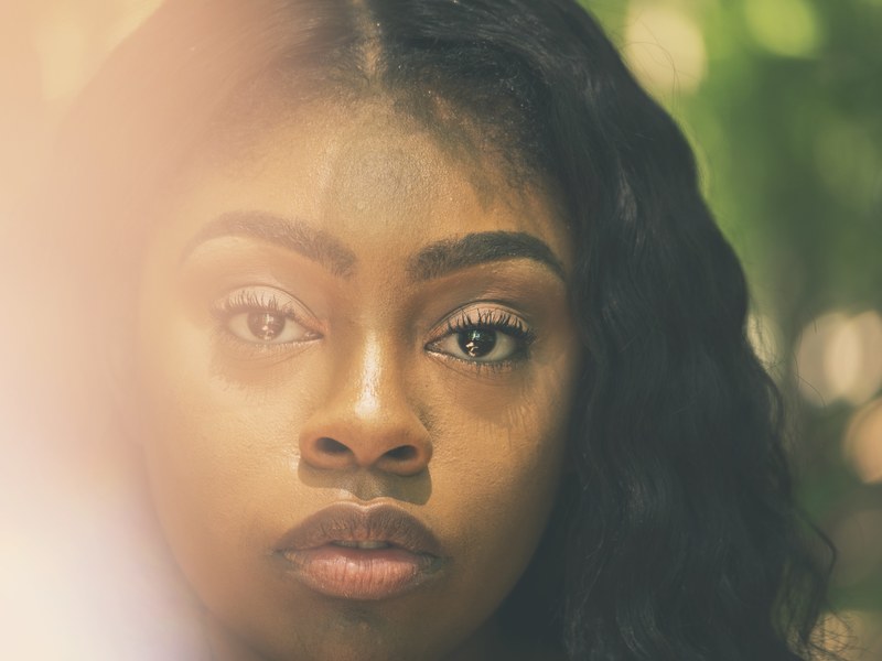a portrait of a womans face with wavy black hair looking into the camera, into the deep 4k