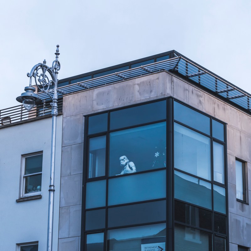 a star wars stormtrooper in an office window seen from the outside, see it from the window 4k