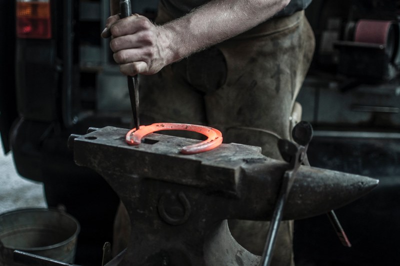 a blacksmith shaping a horseshoe on an anvil, a craftsman at work 4k