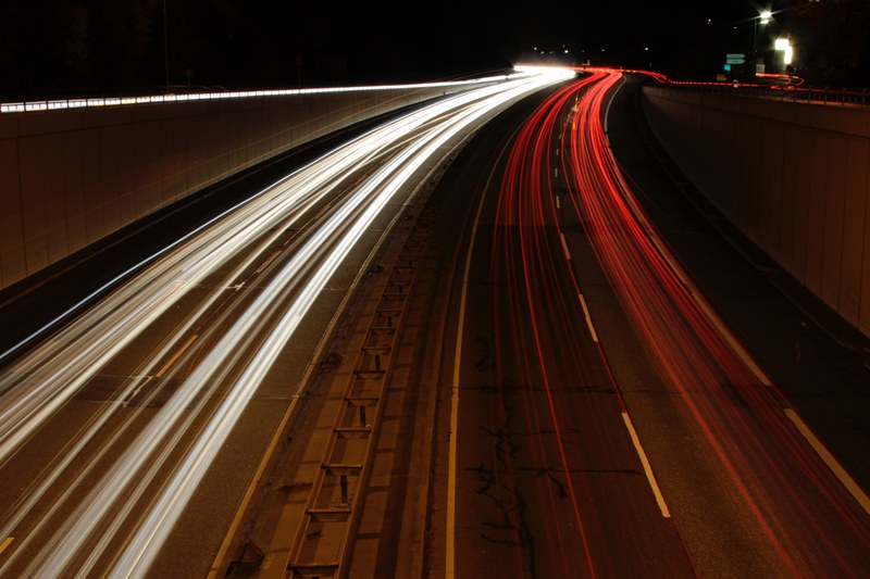 white and red light trails on a two lane highway at night, night over a highway 4k