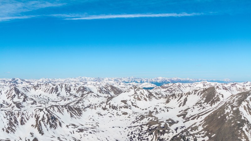 series of snow capped mountain ridges stretching to the horizon, 4k