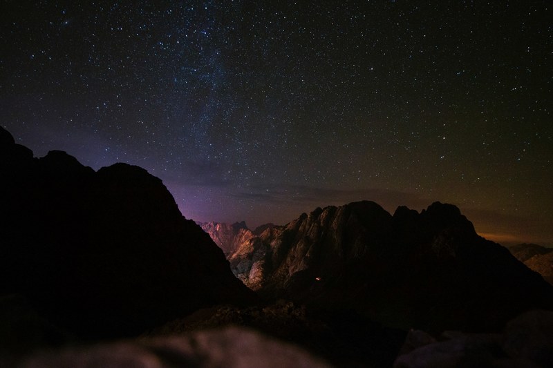 a starry night sky over craggy mountain silhouettes in jabal moussa, lost under the stars 4k