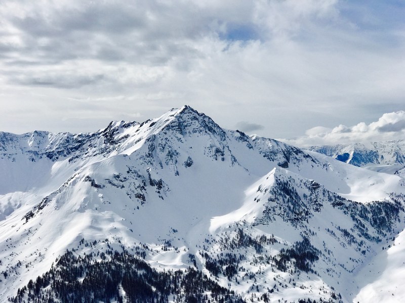 peak of snowy mountain points to the cloudy sky, sharp mountain peak near auron resort 4k