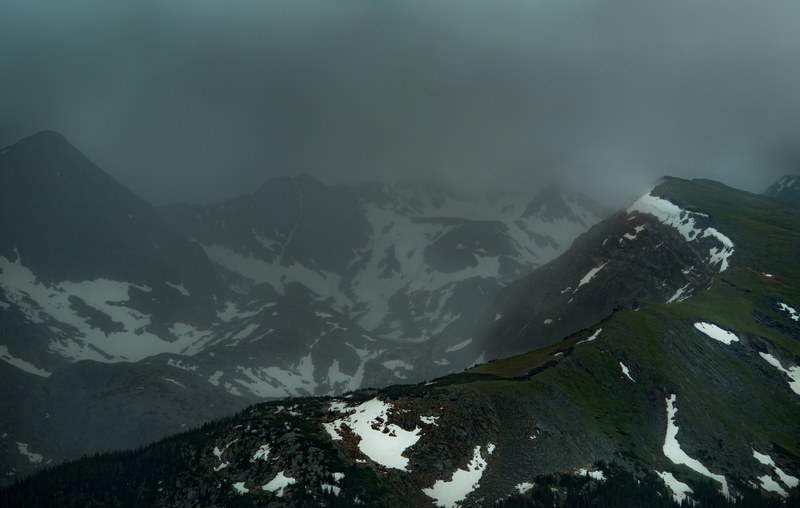 us national park road cuts through grassy foggy mountainsides, dark mountain ridges 4k