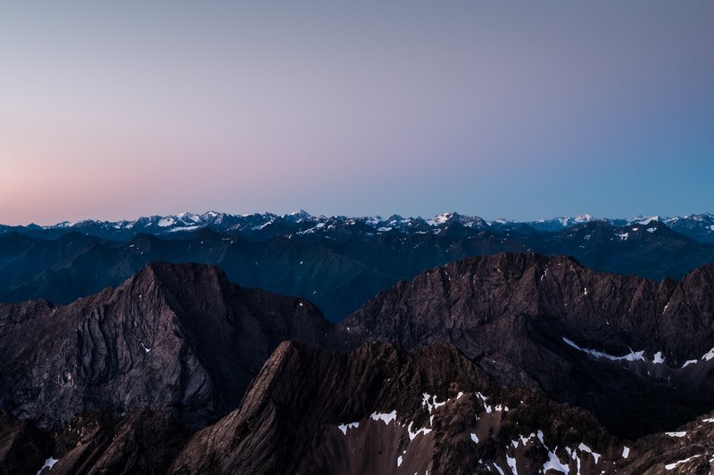 a long mountain range with snow topped peaks in the evening, view from zugspitze 4k
