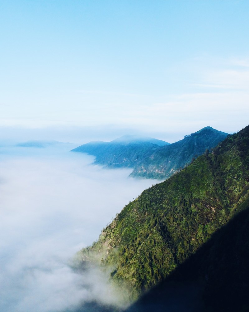 green mountain slopes over a sea of clouds, green mountains over clouds 4k