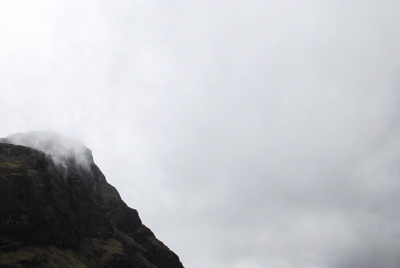 view from a rocky mountain ledge on the white clouds below, clouds obscuring view from a mountain 4k