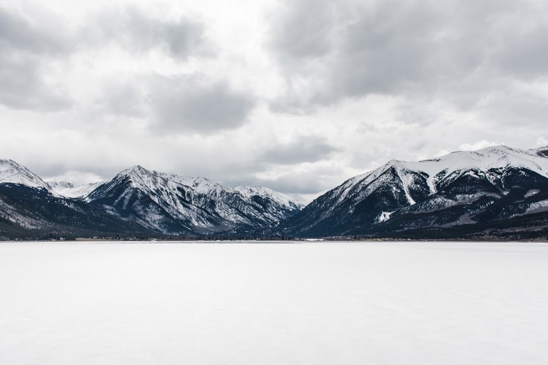 cloudy overhead skies hovering over snowy mountain tops, cloudy skies over mountains 4k