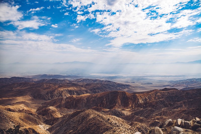 a high shot of dry shrub covered mountains under a cloudy sky, arid mountains 4k